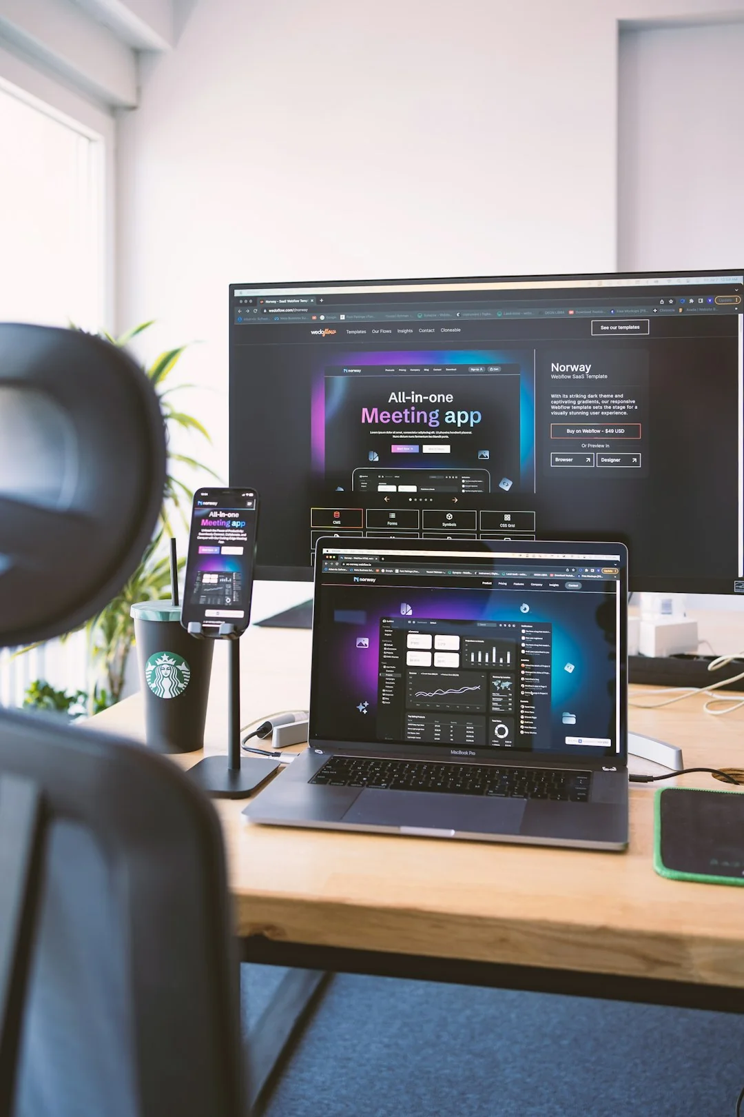 A sleek office desk setup featuring Apple devices: iMac, MacBook, and iPad.