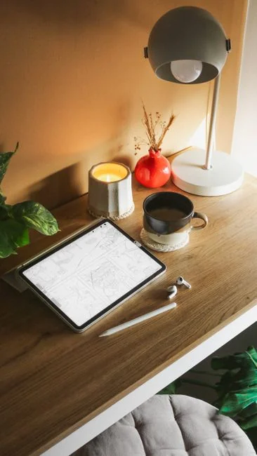 A laptop on a bed displaying web design software, creating a comfortable workspace.